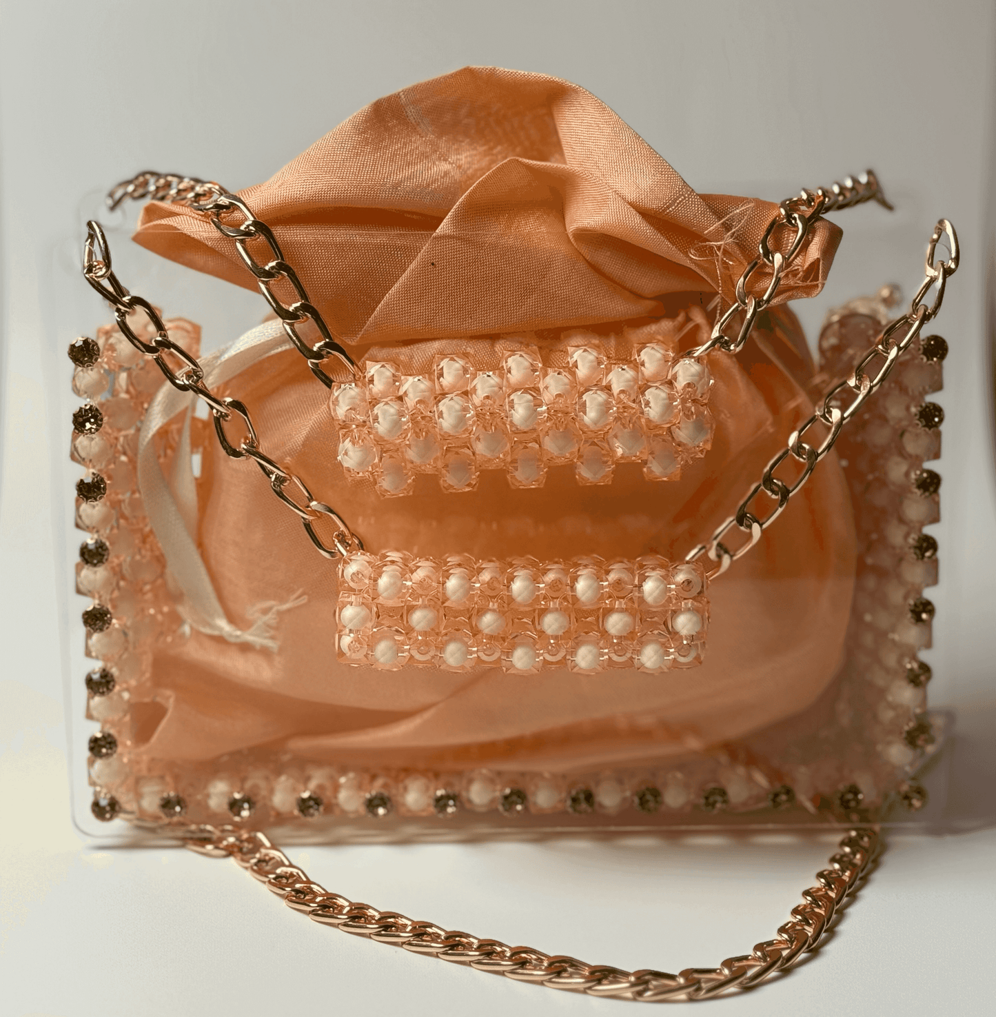Lustre Bloom handbag with peach organza pouch, gem-studded acrylic frame, and gold-tone chain strap