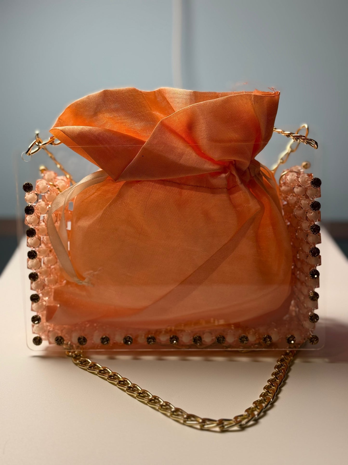 Lustre Bloom handbag with sheer peach organza pouch, gem-studded acrylic frame, and gold chain strap