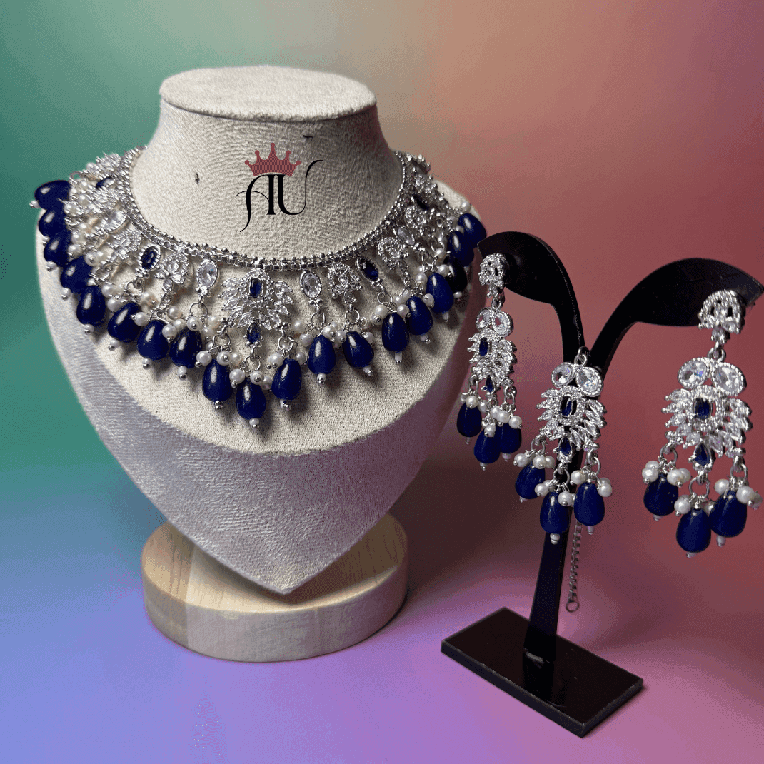 Jewelry set with necklace and earrings on a mannequin and stand against a gradient background